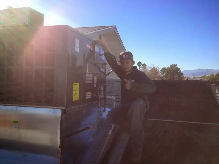 HVAC technician performing Heat Pump Repair on a rooftop unit in Loughman